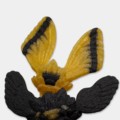 Detailed view of the dragon’s black and yellow moth-like tail